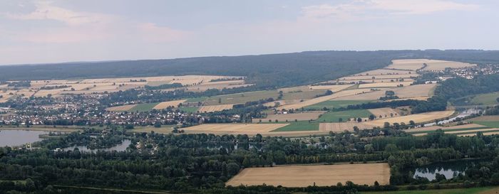 Aerial view of agricultural landscape and buildings against sky