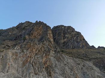 Rock formations on mountain against clear sky