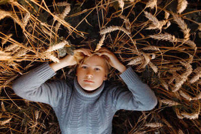 Directly above portrait of woman lying on plants