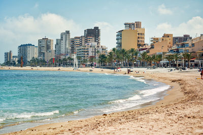 Beach in city against sky