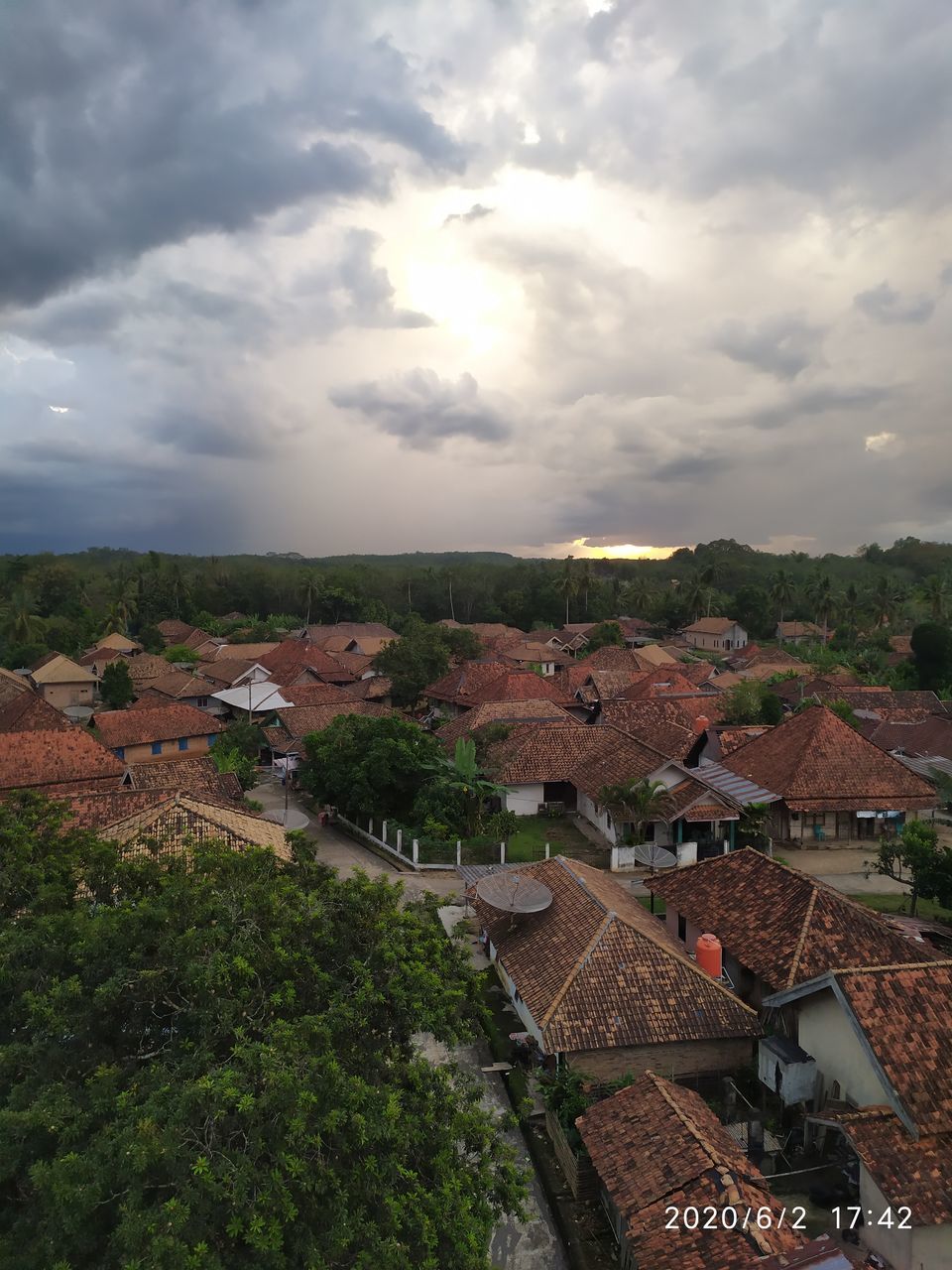 HIGH ANGLE VIEW OF TOWNSCAPE AND TREES AGAINST SKY