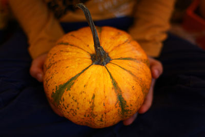Close-up of hand holding pumpkin during autumn