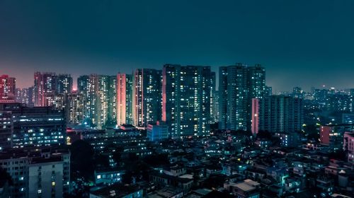 Illuminated cityscape against clear sky at night