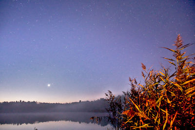 Scenic view of lake against clear sky at night