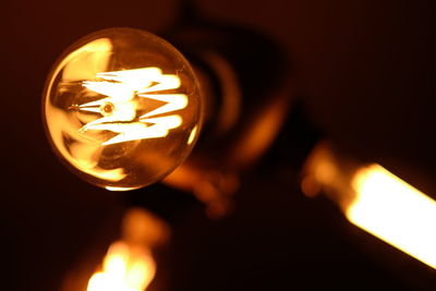 Close-up of lit candle in dark room