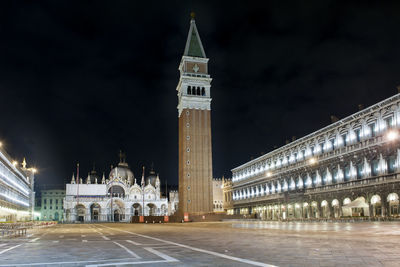 Clock tower amidst buildings in city at night