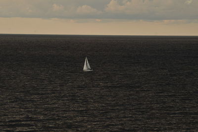 Sailboat sailing on sea against sky during sunset