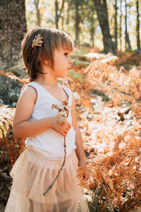 Full length of cute girl standing in forest