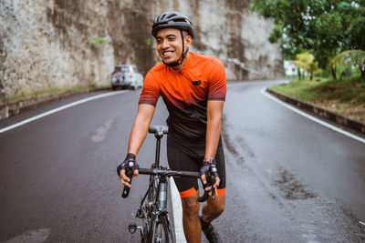 Man wheeling with bicycle on road