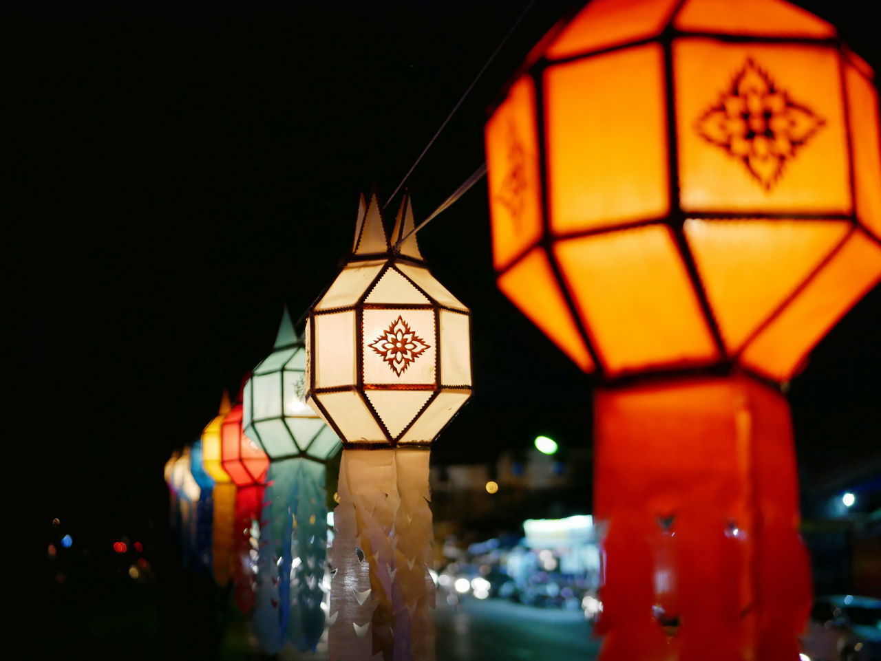 LOW ANGLE VIEW OF ILLUMINATED LANTERNS HANGING FROM CEILING