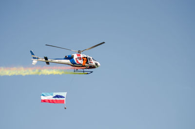 Low angle view of airplane flying against clear blue sky