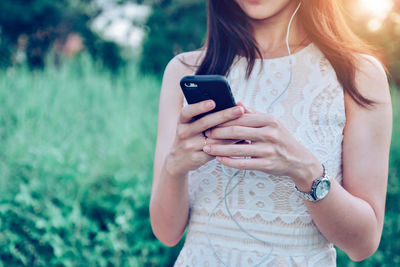 Midsection of woman using mobile phone