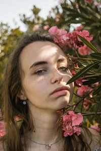 Close-up portrait of woman with pink flower