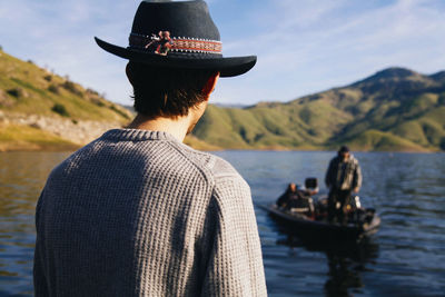 Rear view of man wearing hat against sky