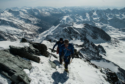 Man standing on snow covered mountain against sky