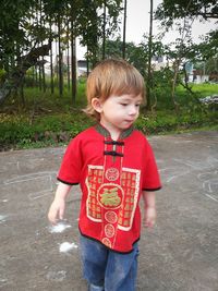 Boy looking away while standing on road