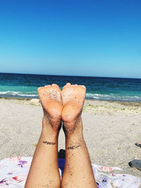 Low section of person relaxing on beach