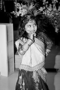 Portrait of smiling girl standing against wall