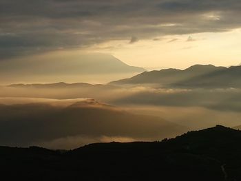 Scenic view of silhouette mountains against sky during sunset