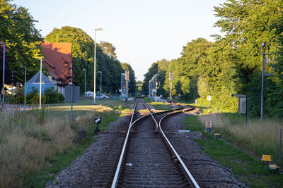 Railroad tracks amidst trees against clear sky