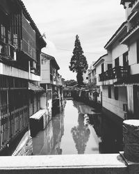 Canal amidst buildings against sky