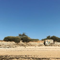 Scenic view of desert against clear blue sky