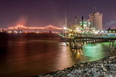 Illuminated bridge over sea at night