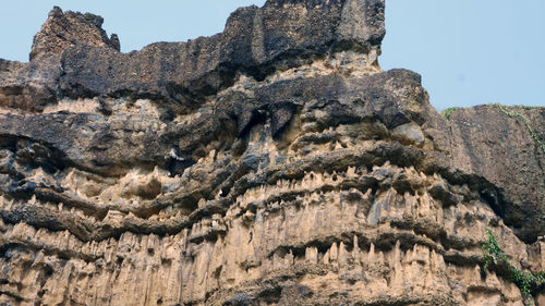 Low angle view of rock formations against sky