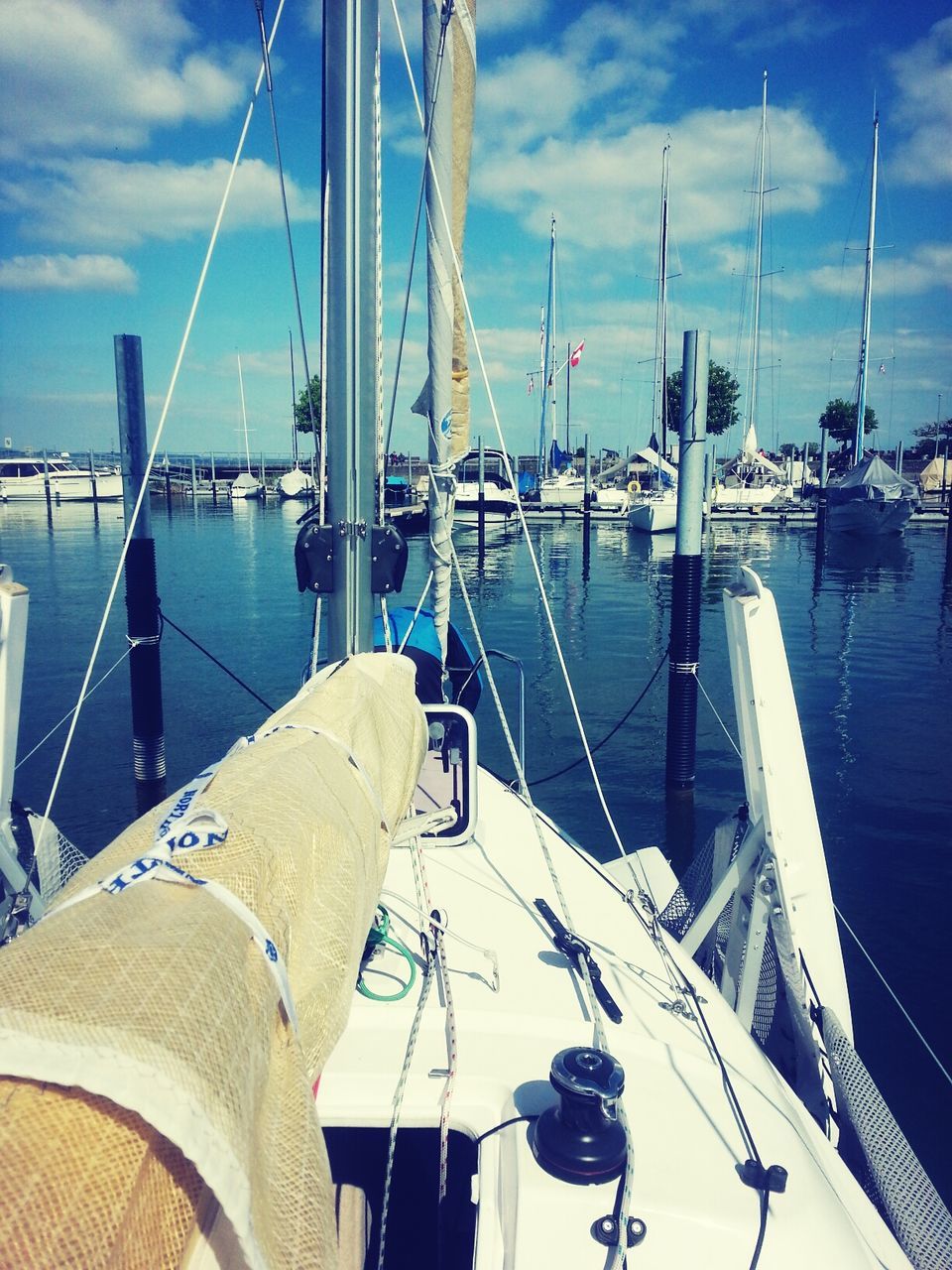 nautical vessel, transportation, boat, water, sky, moored, mode of transport, sea, mast, sailboat, harbor, cloud - sky, cloud, blue, rope, travel, marina, yacht, built structure, waterfront