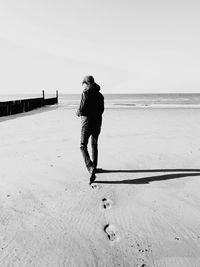 Rear view of man walking on beach