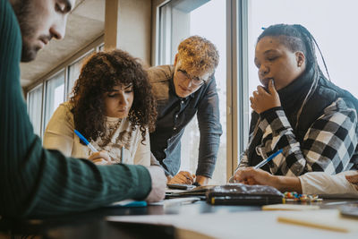 Multiracial students learning together in cafeteria at university