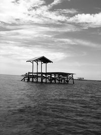 Gazebo on pier over sea against sky