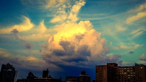 Low angle view of buildings against cloudy sky