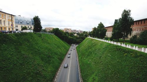 Road amidst buildings in city against sky