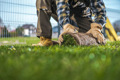 Low section of man sitting on field