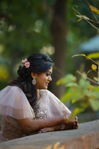 Side view of young woman looking away outdoors