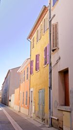 Residential buildings by street against sky