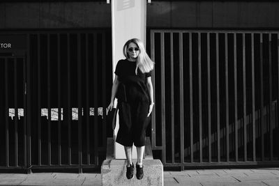 Portrait of woman standing against wall