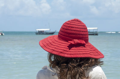 Rear view of woman in hat against sea