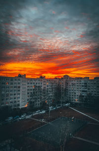 High angle view of buildings against dramatic sky during sunset