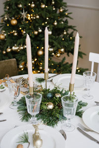 Beautiful glass glasses, candles in the decor of the festive table. christmas table setting