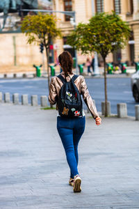 Full length rear view of man walking on street