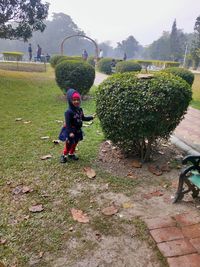 Children playing on footpath by trees