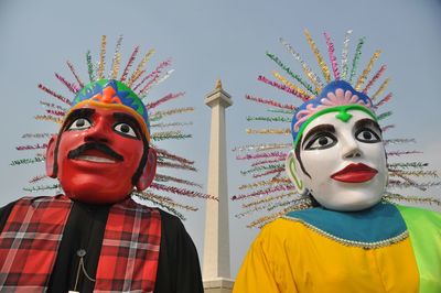 Low angle view of giant puppets against clear sky