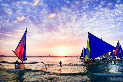 Tourists on boat at island of boracay during sunset