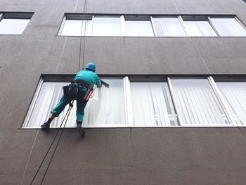 Low angle view of man cleaning window