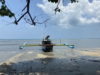Nautical vessel on beach against sky