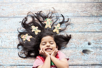 High angle view of cute girl with hair spread lying on wooden floor