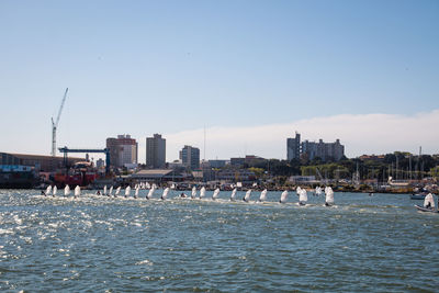 City buildings by sea against clear sky