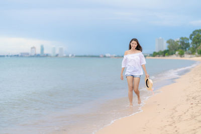 Carefree woman walking on shore at beach